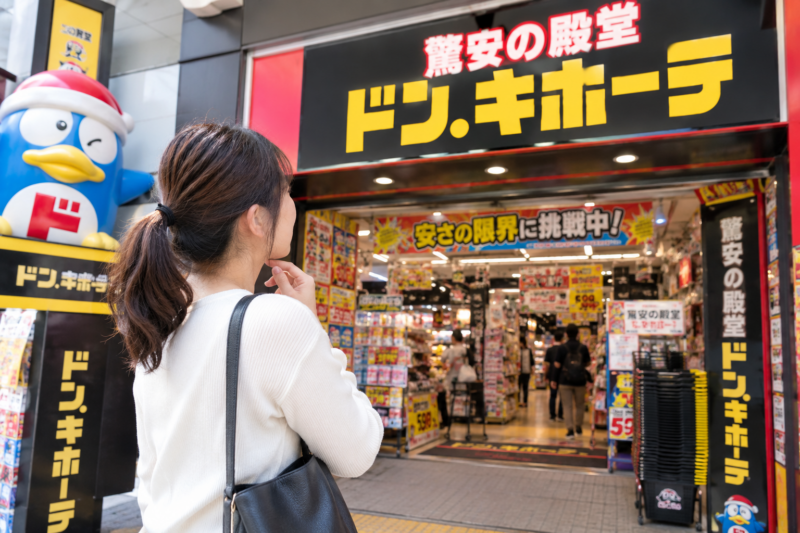 ドン・キホーテの入口で買い物をする女性